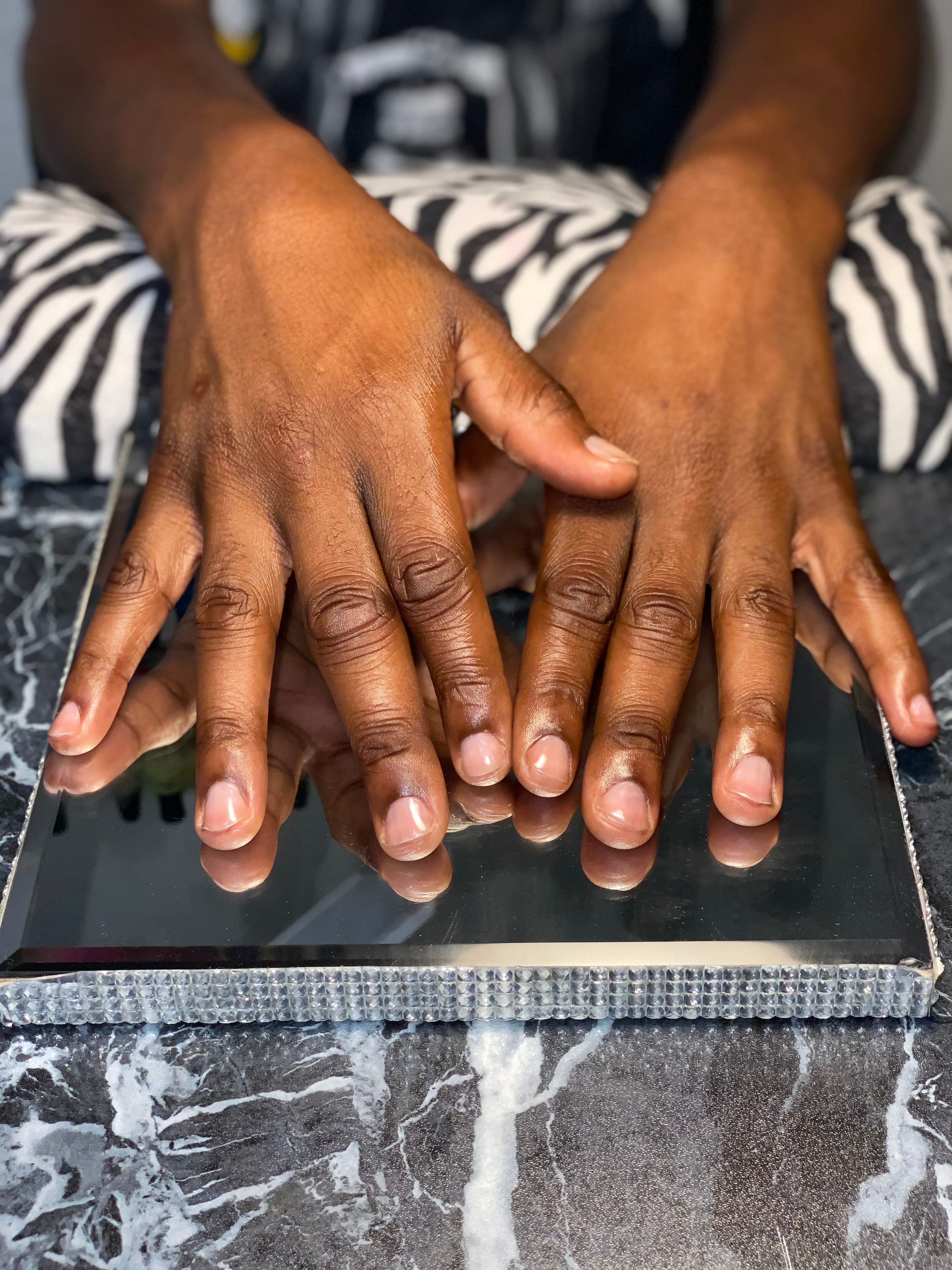 Natural manicured nailz on a rhinestone-framed mirror tray